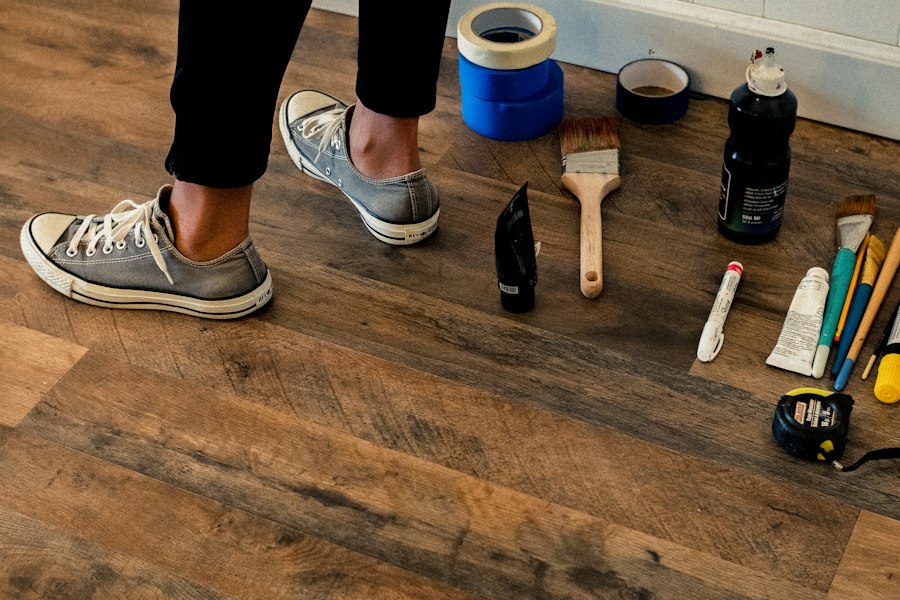 Tape, brushes and a tape measure on a newly installed wood-look plank floor