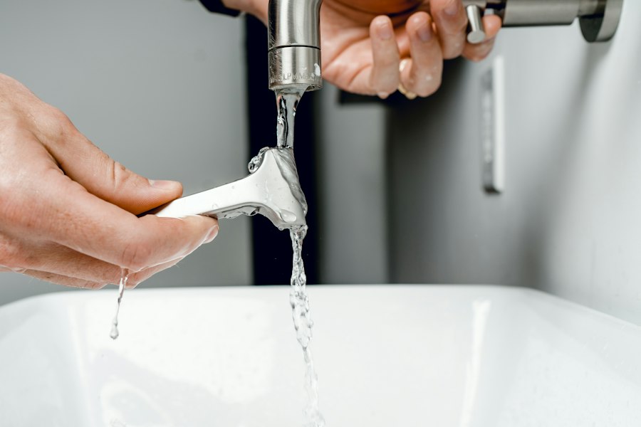 Hands fitting a part onto a running bathroom faucet